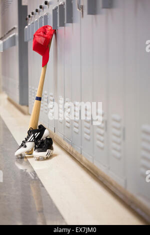Baseball bat and clothing by lockers Stock Photo