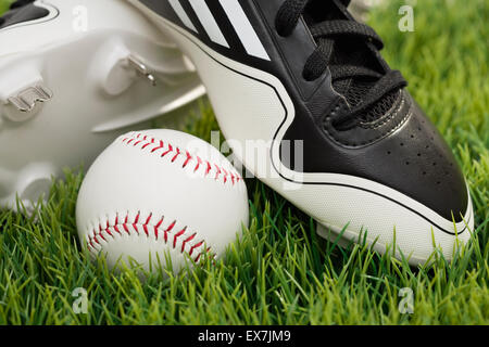 Baseball shoes and ball on grass Stock Photo