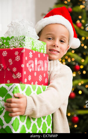Boy (6-7) holding stack of Christmas presents Stock Photo