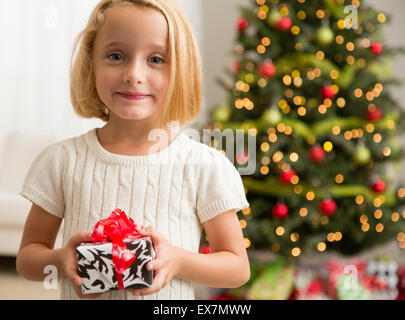 Girl (6-7) holding Christmas present Stock Photo