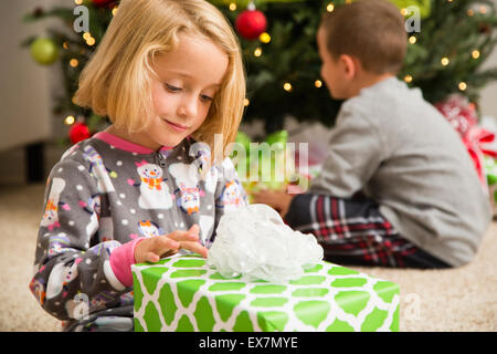 Girl (6-7) wrapping Christmas present Stock Photo