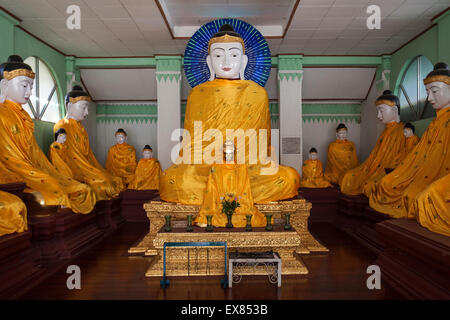 Buddha statues with yellow gowns, Shwedagon Pagoda, Yangon, Myanmar Stock Photo