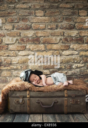 Little pilot boy sleeping on the luggage Stock Photo