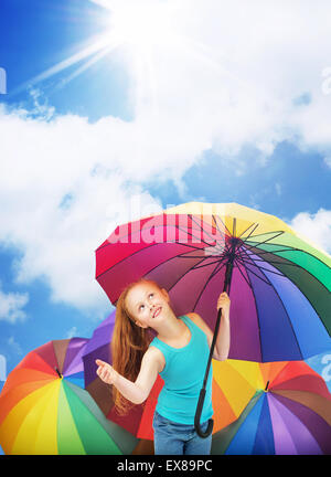 Redhead girl holding a colorful umbrella Stock Photo