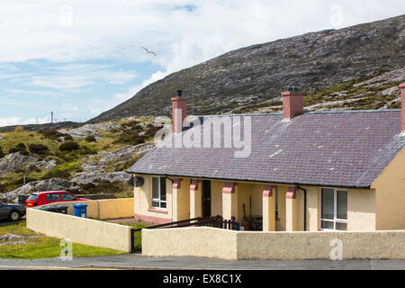 Housing in Tarbert on the Isle of Harris, Outer Hebrides, Scotland, UK, with rugged scenery behind. Stock Photo