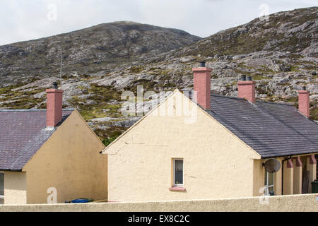 Housing in Tarbert on the Isle of Harris, Outer Hebrides, Scotland, UK, with rugged scenery behind. Stock Photo