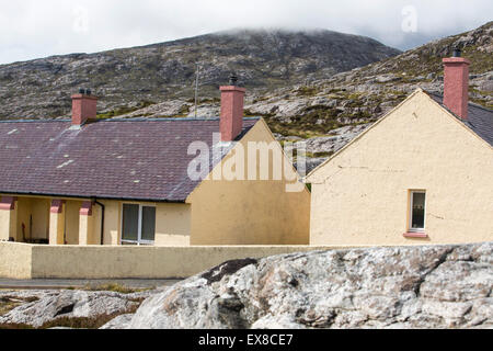 Housing in Tarbert on the Isle of Harris, Outer Hebrides, Scotland, UK, with rugged scenery behind. Stock Photo