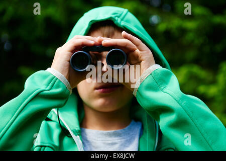 Child boy using binoculars at forest Stock Photo