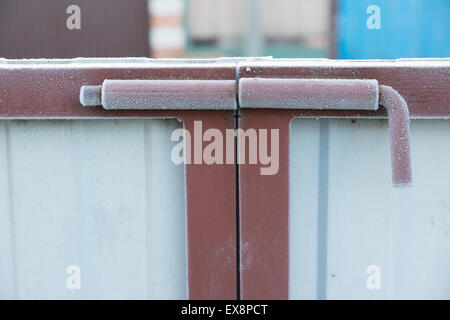 the frozen steel latch serves for closing of gate in the house Stock Photo