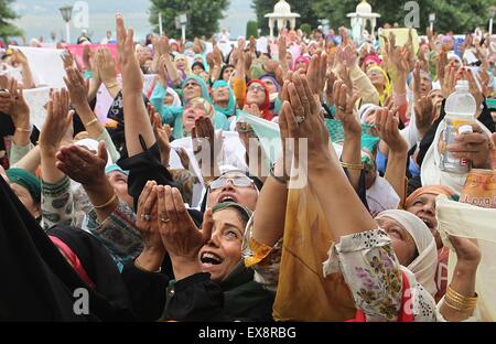 (150709) -- SRINAGAR, July 9, 2015 (Xinhua) -- Kashmiri Muslim devotees raise their hands to seek blessings as a head priest displays a relic of the Prophet Muhammad at the Hazratbal shrine, to mark the Martyr Day of Hazrat Ali during Ramadan, in Srinagar, the summer capital of Indian-controlled Kashmir, July 9, 2015. Muslims across the world refrain from eating, drinking and smoking from dawn to dusk to observe the holy fasting month of Ramadan. (Xinhua/Javed Dar) Stock Photo