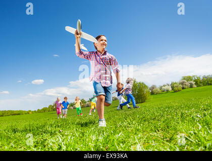View from below of boy with toy and kids running Stock Photo