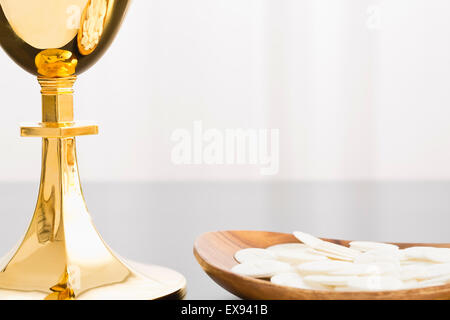 Christian holy communion, gold chalice and communion wafer on plate Stock Photo