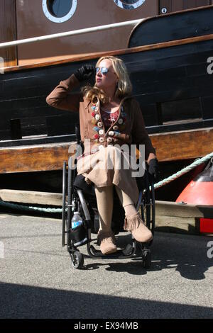 Naked disabled female in green body paint in crowd participating in