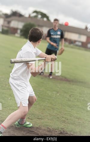 school students play baseball / rounders during physical education, outside, on the pitch Stock Photo
