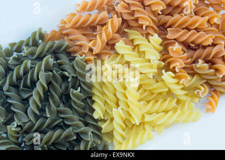Tri-Color unprepared macaroni pasta stacked to form background Stock Photo
