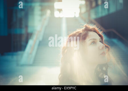 young beautiful hipster woman with red curly hair in the city Stock Photo