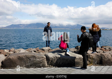 asian tourists take photos on saebraut sea coastal road reykjavik iceland Stock Photo