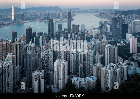 China, Hong Kong, View of towering skyscrapers in city skyline from viewpoint atop Victoria Peak at sunset on winter evening Stock Photo