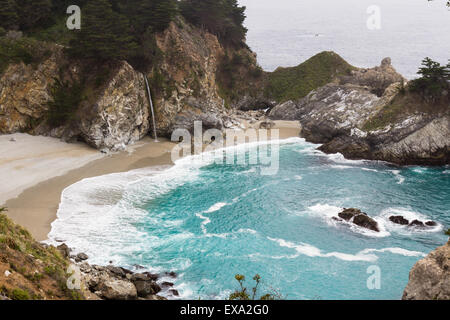 Waterfall in Julia Pfeifer Burns State Park, on a cloudy day, with turquoise water Stock Photo