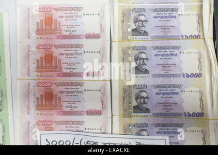 Dhaka, Bangladesh. 10th July, 2015. Members of Rapid Action Battalion (RAB) in a drive arrested two suspected members named Md. Hamidur Rahman (second right) and Jamila Akhter Mazina (second left) of a counterfeit money syndicate, from Adabar, in Dhaka, Bangladesh. The elite force members also recovered counterfeit notes worth BDT 2.5 million and fake currency making equipments from their possessions. Credit:  Suvra Kanti Das/ZUMA Wire/ZUMAPRESS.com/Alamy Live News Stock Photo