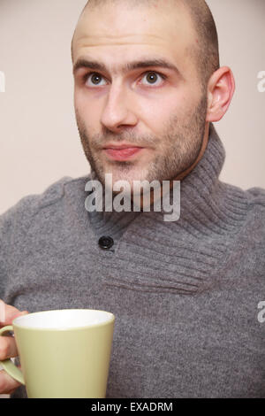 fashion portrait of handsome young man in a gray sweater isolated on light background Stock Photo