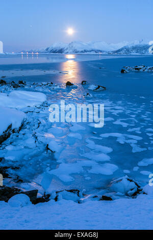 Reflections of full moon in the frozen sea, Lyngedal, Lofoten Islands, Arctic, Norway, Scandinavia, Europe Stock Photo