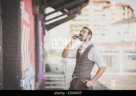 handsome big moustache hipster man smoking pipe in the city Stock Photo