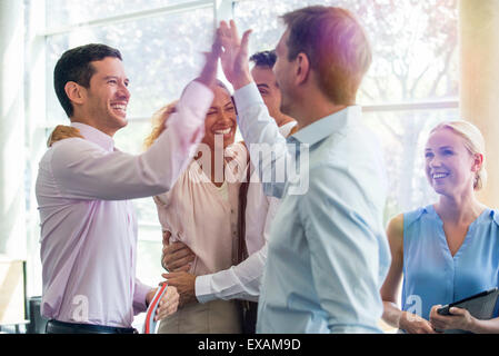 Colleagues giving each other high-five Stock Photo