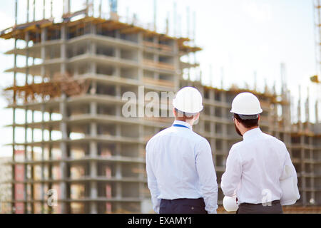 Male architects standing in front of new construction Stock Photo