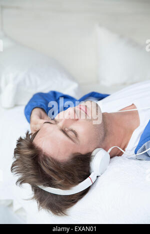 Man wearing headphones lying on back Stock Photo
