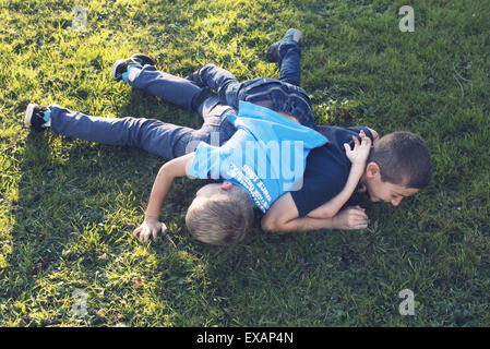 Young brothers playing together on lawn Stock Photo