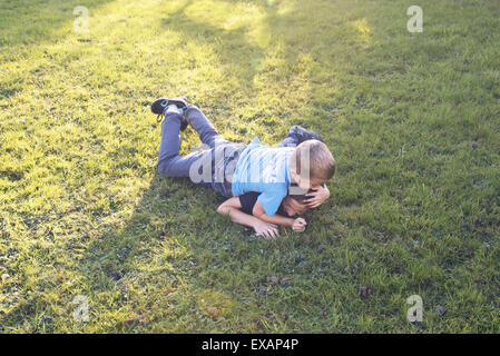 Boys wrestling on lawn Stock Photo