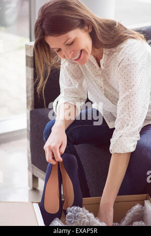 Woman unpacking box of new shoes Stock Photo