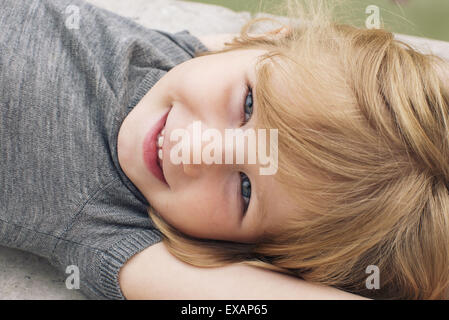 Little girl lying on her back, smiling, portrait Stock Photo