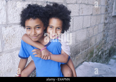 Young siblings embracing outdoors, portrait Stock Photo