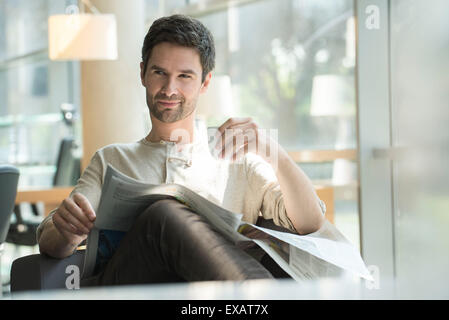 Man relaxing with newspaper and cup of coffee Stock Photo