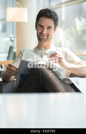 Man relaxing with coffee and newspaper Stock Photo