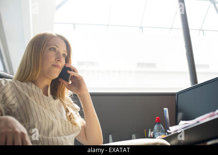 Office worker making phone call at desk Stock Photo