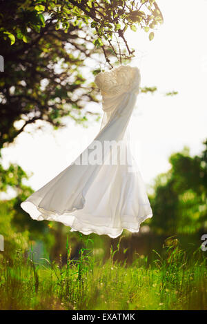White wedding dress hangs on a hanger on the arched wrought-iron ...
