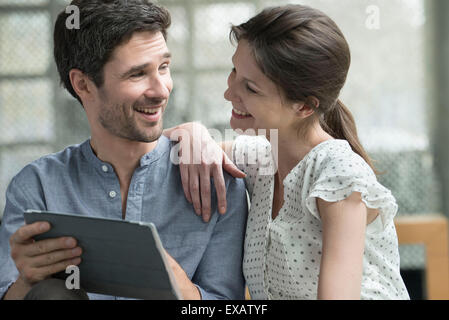 Couple using digital tablet together at home Stock Photo