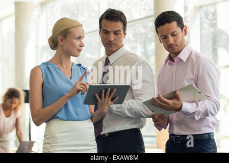 Businesswoman showing colleagues digital tablet Stock Photo