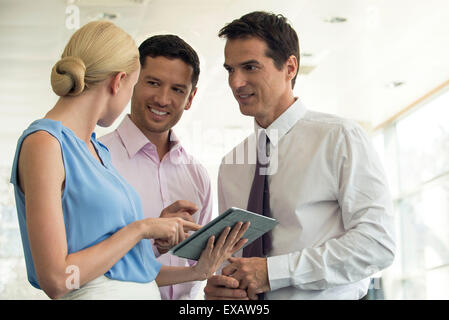 Professionals collaborating using digital tablet Stock Photo