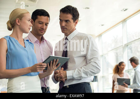 Colleagues looking at digital tablet together Stock Photo