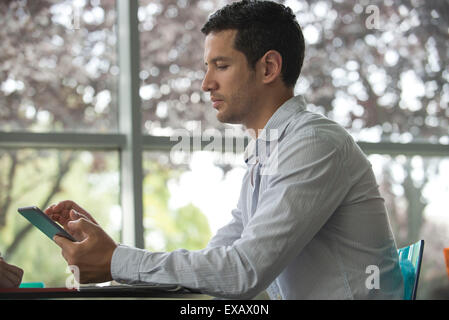 Man using digital tablet, side view Stock Photo
