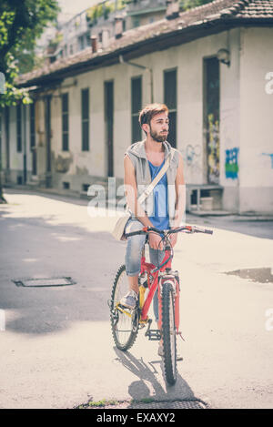 young hipster gay man with bike in the city Stock Photo