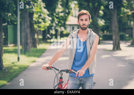 young hipster gay man with bike in the city Stock Photo