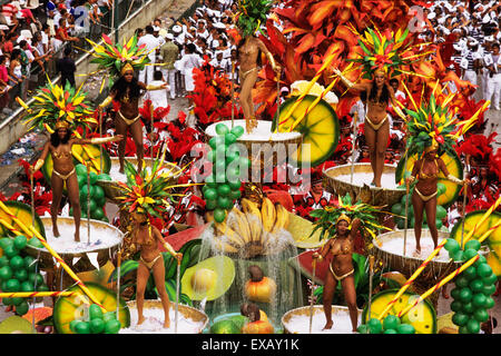 Rio de Janeiro, Brazil. Carnival samba school parade; float with fruit coctail theme; girls in scanty gold bikinis. Stock Photo