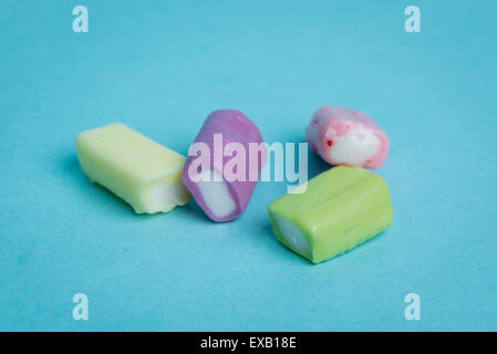 Strawberry, grape, banana and green apple chewy candies on a blue background. Stock Photo
