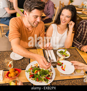 Happy couple at the restaurant and being served of food in the plate Stock Photo