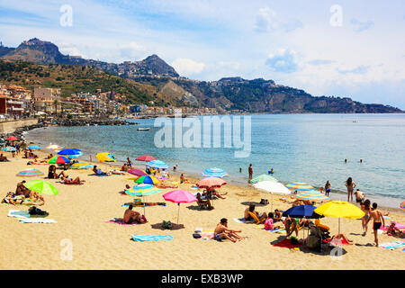 Beach at Giardini Naxos, Messina district, Sicily with a view to Cape Taormiina and the hilltop villages of Taormina Stock Photo